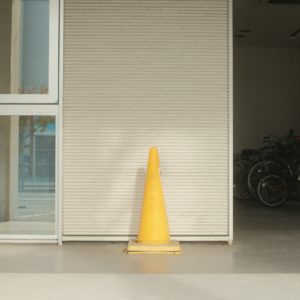 a yellow cone sitting in front of a building