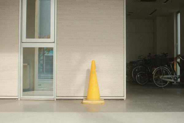 a yellow cone sitting in front of a building
